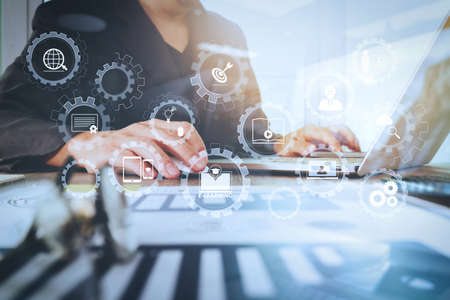 E-learning with connected gear cogs connected diagram virtual dashboard.business documents on office table with laptop computer with smart phone and graph business diagram and man working in the backgroundの写真素材
