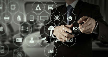 Internet of Things (IOT) technology with AR (Augmented Reality) on VR dashboard. Businessman hand pressing an imaginary button on virtual screenの写真素材
