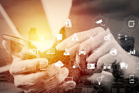 Internet of Things (IOT) technology with AR (Augmented Reality) on VR dashboard.  businessman hand working with mobile phone and laptop and digital tablet computer in modern office with London city exposureの写真素材