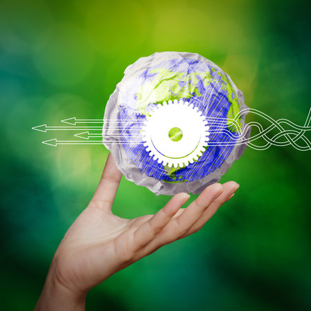 Thinking about structuring virtual diagram of business process with solutions. hand showing crumpled world paper symbol as concept on green backgroundの写真素材