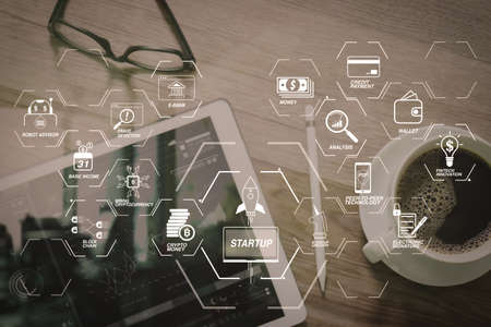 Financial technology flowchart and basic income mining cryptocurrency with blockchain startup unicorn crypto money virtual diagram.Coffee cup and Digital table dock smart keyboard,eyeglasses.の写真素材