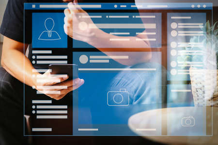 Web page browser of Social media Page VR Interface on the laptop computer.designer man hand using smart phon for mobile payments online shopping,omni channel,sitting on sofa in living room.の写真素材