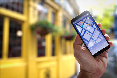 Close up of Tourist using GPS map navigation on smartphone application screen for direction to destination address in the city with travel and technology concept.の写真素材
