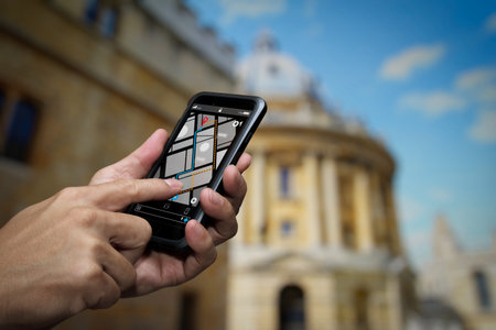 Close up of Tourist using GPS map navigation on smartphone application screen for direction to destination address in the city with travel and technology concept.の写真素材
