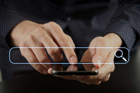 Searching Browsing Internet Data Information Networking Concept with blank search bar.close up of businessman hand working with mobile phone in modern officeの写真素材