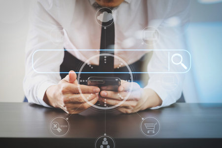 Searching Browsing Internet Data Information Networking Concept with blank search bar.close up of businessman working with smart phone on wooden desk in modern office with virtual icon diagramの写真素材