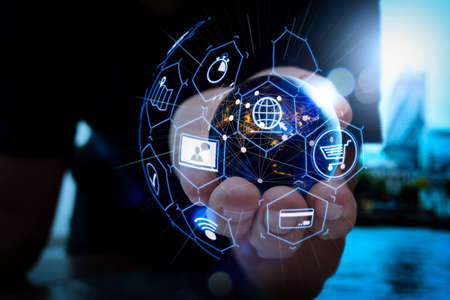 E-commerce concept with VR digital interface with icons of shopping cart and delivery truck and credit card with symbol of online purchase on internet.Hand holding Global world telecommunication network connected.の写真素材