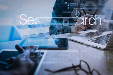 Searching Browsing Internet Data Information Networking Concept with blank search bar.medical doctor hand working with smart phone,digital tablet computer,stethoscope eyeglass on wooden desk.の写真素材