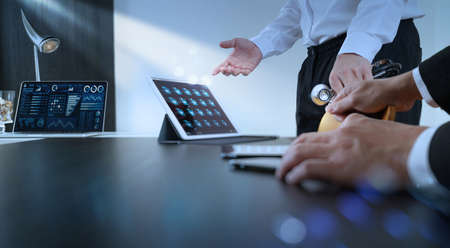Medical health care technology network team meeting concept.Doctors with tablet pc computer and smart phone at seminar or hospital business finance insurrance document records.の写真素材