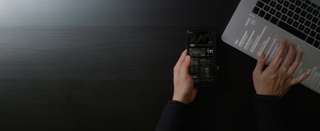 top view of  businessman using smartphone investment concept, invest money, business and finance, graph charts, work desk background.の写真素材