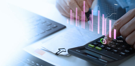 Businessman using calculator with marketing  data growth graph and progress of business and analyzing financial and investment information, business planning and strategy.の写真素材