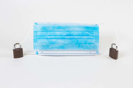 Medical protective mask on white background, prevent coronavirus, with two iron locks on the ropes of the mask.の写真素材