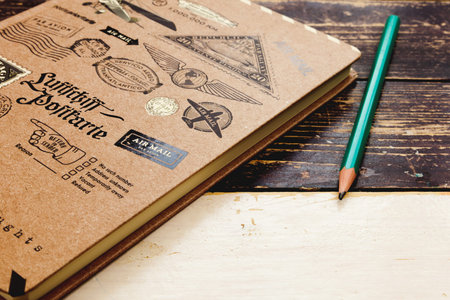 The notebook is lying on a wooden table, next to a green pencil.