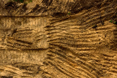Embossed trail excavator tracks on the wet sand.の写真素材