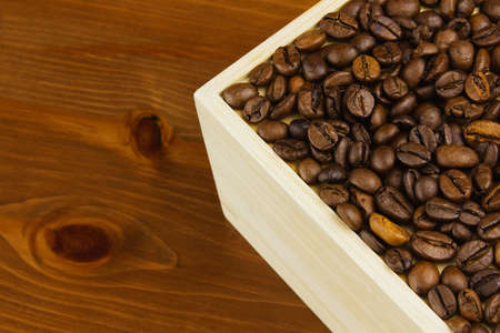 Coffee beans in a box on the background of a wooden table.の写真素材