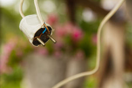Hung white plug with the winding, the background is blurred.の写真素材