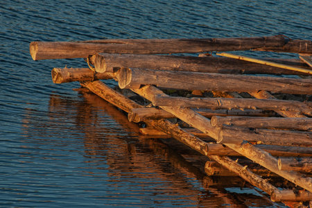 Wooden pier made of timber on the background of water, the White sea of the Arctic, at sunset.