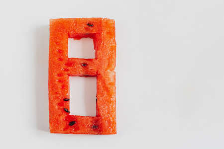 Number 8, the digit eight carved from a fresh watermelon on a white background.の写真素材