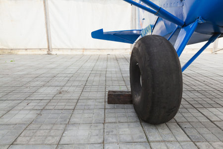 Big wheel for a small private plane, blue plane in the hangar. Bush pilot.