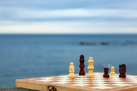 Playing chess on a Board on the beach. Chessboard on the background of the sea on a Sunny day....