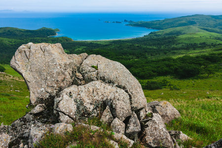 Large rocks on top of a hill, background summer coastline of Astafiev Bay, Primorsky Krai, Russia.