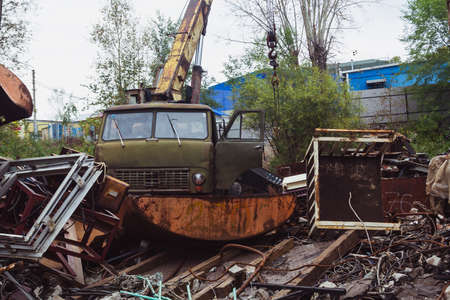 Scrap yard, crane in the background, metal waste disposal.の写真素材