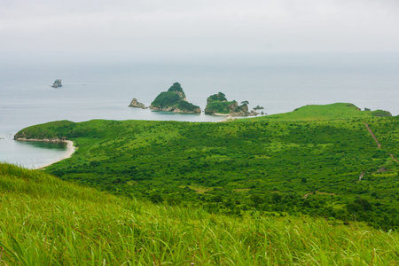 Bay of the sea from the top of a hill of a mountainous coast with an island in the background,...