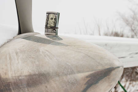 A dollar, a bundle of rolled-up dollars is on the prop of a private plane.のeditorial素材