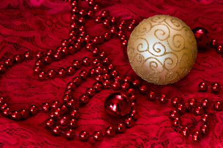 Christmas decorations on a red background Accessories. Gold Ball toy with red lace. New year toyの写真素材
