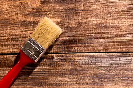 red paintbrush on  burnt wooden backgroundの写真素材