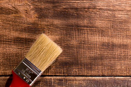 red paintbrush on  burnt wooden backgroundの写真素材