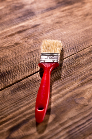 red paintbrush on  burnt wooden backgroundの写真素材