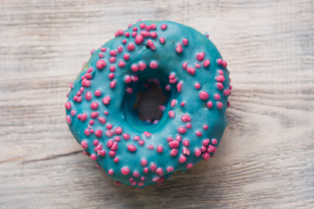 glazed donuts with sprinkles on a white wooden tableの写真素材