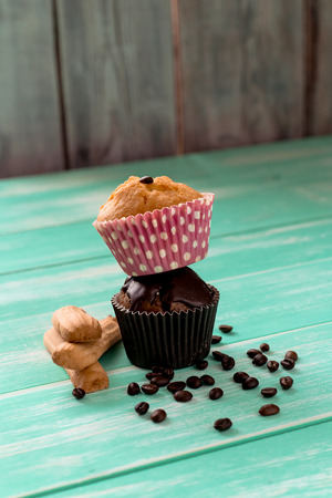 stack of cupcakes with coffee beans and cookies on a green wooden tableの写真素材