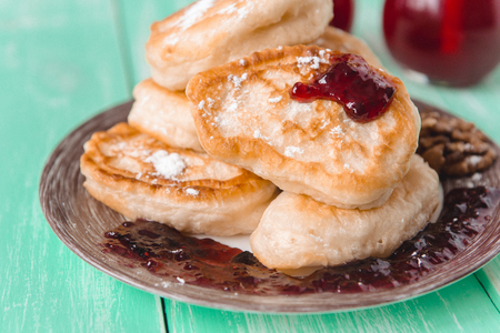 pancakes with jam and glasses of juice on a wooden tableの写真素材