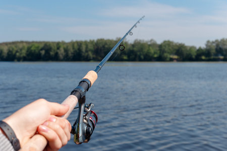 men's hand holding spinning and fishing