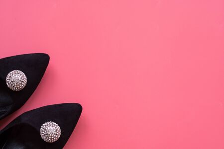 close up black suede women's shoes with rhinestones on a pink background with a copy space top viewの写真素材