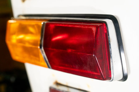 rear lantern or headlight of an old car with a white rusty body