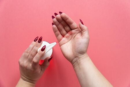 Woman's hand squeezes out liquid soap and dispenser. Hand bacteria treatment conceptの写真素材