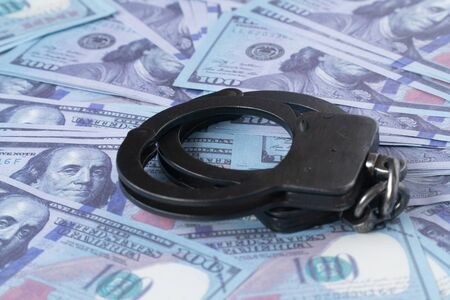 handcuffs against the background of hundred-dollar billsの写真素材