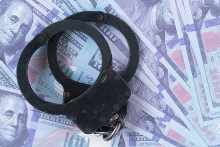 handcuffs against the background of hundred-dollar billsの写真素材