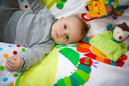 Newborn child relaxing in bed. Nursery for young children.の写真素材