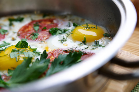 Chicken egg fried in a pan with tomatoの写真素材