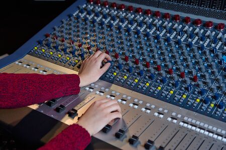 An expert adjusting audio mixing consoleの写真素材