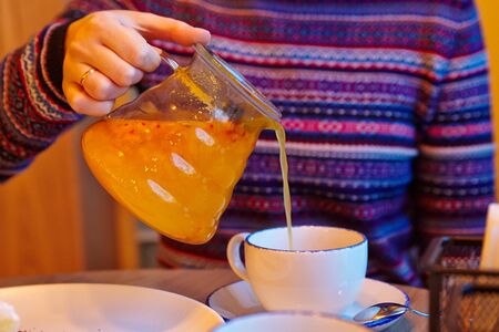 Woman pouring tea into the cupの写真素材