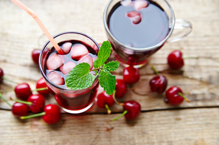 Cherry juice in glasses with ice and mint On the rustic table, view from aboveの写真素材