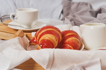 Breakfast in bed, coffee, book, croissants with jamの写真素材