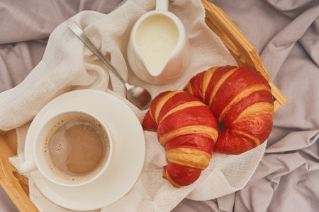 Breakfast on a crumpled bed, coffee, croissantsの写真素材