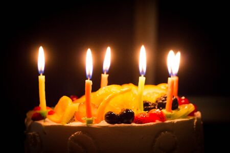 beautiful birthday cake with candles and fruitの写真素材