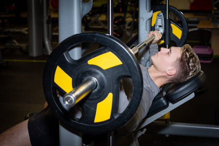 Young athlete men has fit training with barbell in the gym